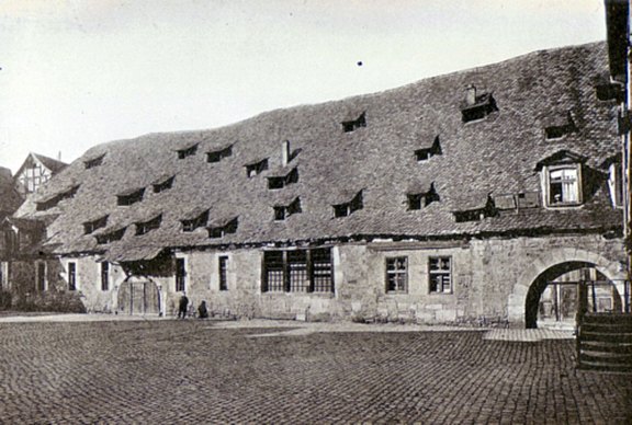 Mühle vom Mühlenplatz mit Sicht auf zwei Tore in der großen Sandsteinmauer des Gebäudes 
