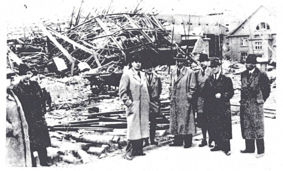 Dr. Vits mit Herrn des Ausichtsrates und des Vorstandes vor den Trümmern des Baues 3, April 1944 