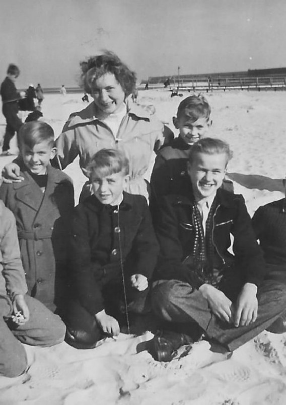 Jungengruppe mit Erzieherin am Strand 