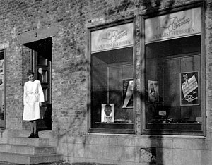 Das erste Geschäft des Optiker Osterberg in der Leipziger Straße 153, Auf der Treppe steht Frau A. Osterberg.