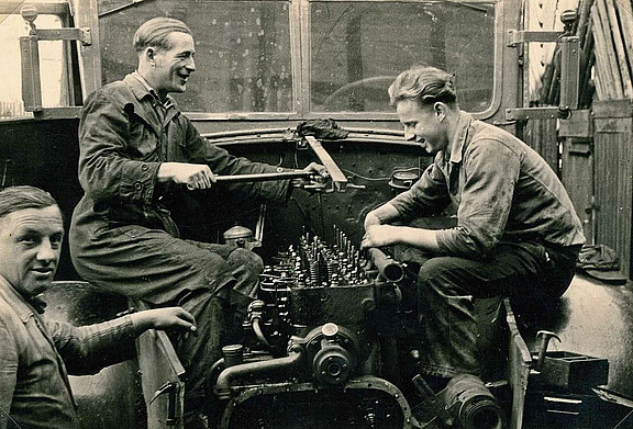 Hans Hess, Mechaniker Willi Pfaffenbach aus Waldau und der Sohn Günther Hess beim „Tuning“ des LKW-Motors
