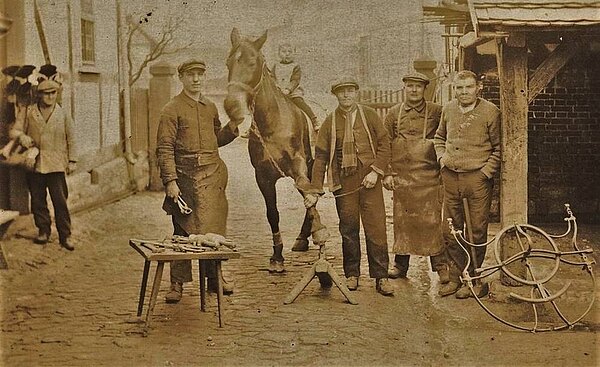 Schmiedemeister und Geselle bei der Arbeit