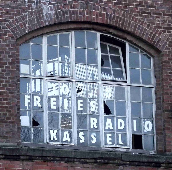 Fenster mit zerbrochenen Scheiben und der Schriftzug -Freies Radio Kassel-