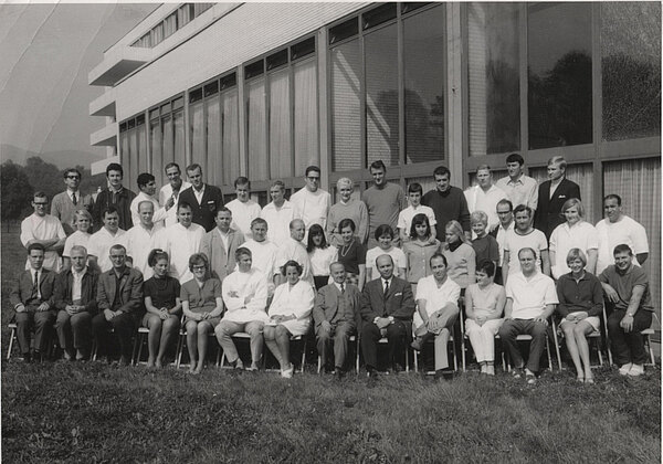 Gruppe von Schüler und Ausbilder sitzen vor dem Gebäude der Rohrbachschul
