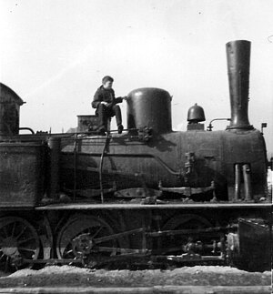 Ein Junge sitzt auf dem Kessel der Lok