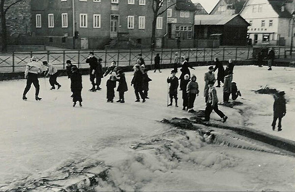 Kinder auf dem Eis der Losse 1953, im Hintergrund Holz-Notkirche am Dorfplatz