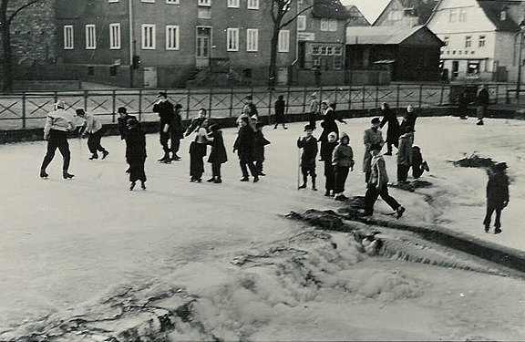 Kinder auf dem Eis der Losse 1953, im Hintergrund Holz-Notkirche am Dorfplatz 