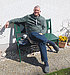 Klaus-Peter Hünnerscheidt sitzt lächelnd auf einer Bank im Garten
