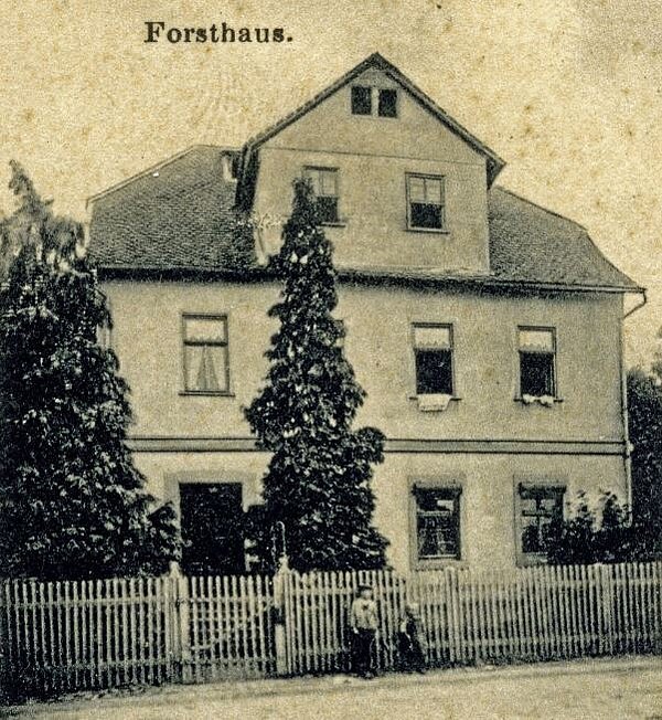 Ansicht des alten Forsthauses von der Straße, zwei Kinder am Zaun