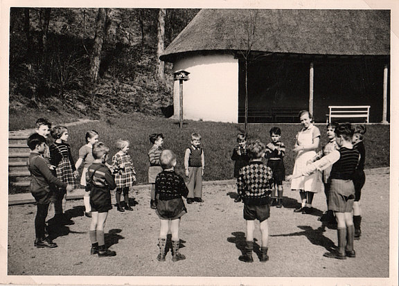 Kinder im Kreis mit Erzerzieherin 1955 