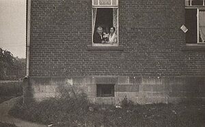 Oma und Opa schauen aus dem Wohnzimmerfenster in den Hof