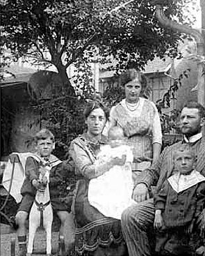 Familie Winkelstein sitzen in ihrem Garten. 1911