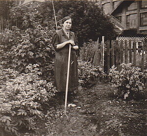 Oma bei der Gartenarbeit. Im Hintergrund die Firma Salzmann.