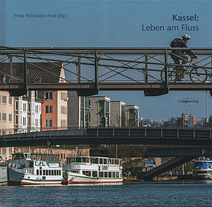 Blick auf die Schlagd mit Fahrgastschiffen in der Fulda, oben darüber ein Fahrradfahrer auf der Walter-Lübcke-Brücke