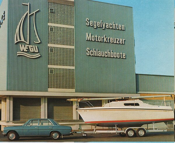 Segelboot Rubin 23 auf Trailer vor dem Werksgebäude Wegu Kassel, Werbung an der Fassade
