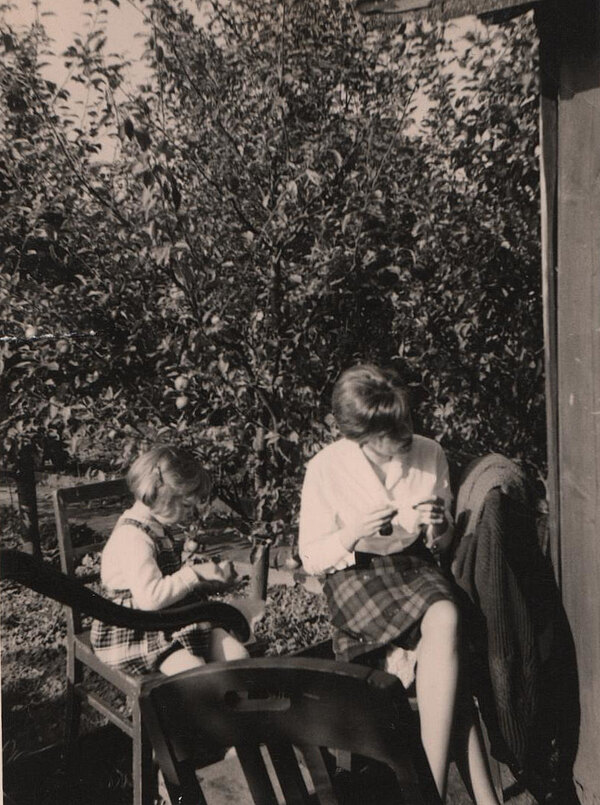 Martina sitzt mit ihrer Schwester im Garten neben dem Gartenhaus