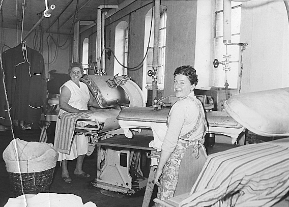 Gertrude Albrecht und eine Büglerin an der Bügelmaschine 