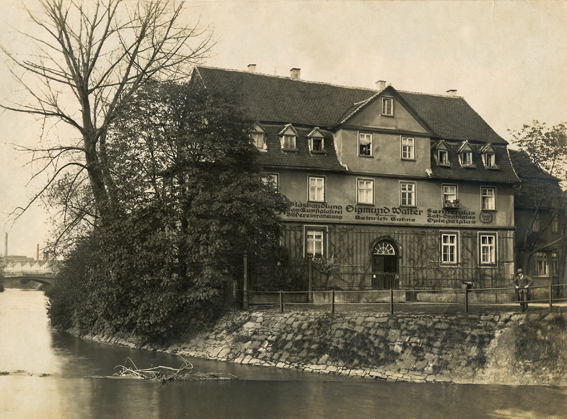 Haus der Glaserei Walter, ein Mann davor schaut auf die Losse, ca. 1920 