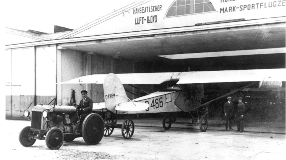 Die D-486 im Einsatz beim Hanseatischen Lluft-Loyd in Hamburg wird mit einem Traktor aus dem Hangar gezogen, ca. 1926 