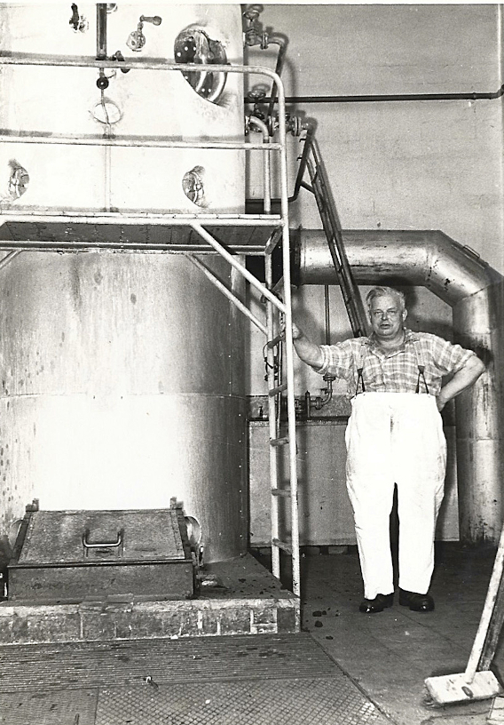H:Albrecht steht neben der Dampfkesselanlage der Wäscherei 
