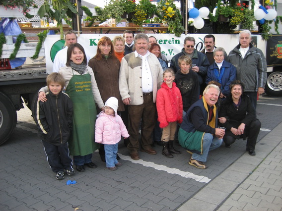 Vereinsmitglieder vor geschmücktem Festwagen 