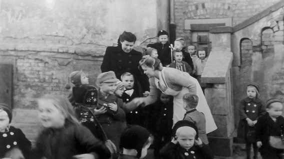 Tante Edith begrüßt die Kinder auf der Treppe. In der Bildmitte stehen meine Mutter und ich. 