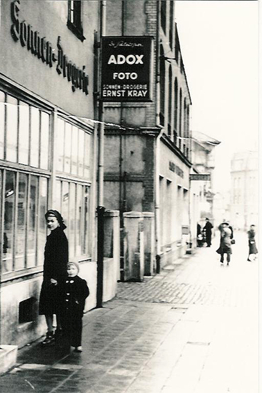 Eine Frau und ein Kind Stehen vor dem Schaufenster der Drogerie Kray 