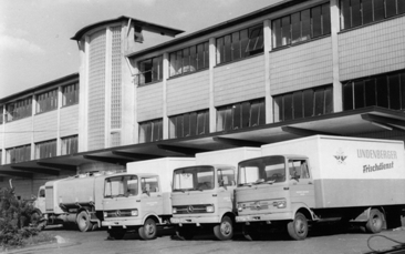 Betriebsgebäude, vor dem mehrere LKW stehen 