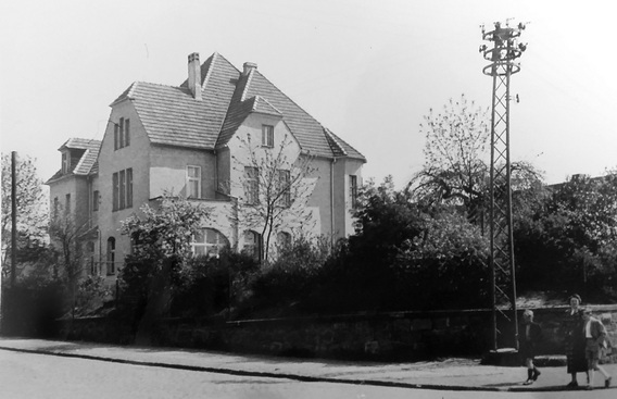 Das Pfarrhaus 1951 von der Eichwaldstraße aufgenommen. im Vordergrund eine Frau mit zwei Kindern und ein Strommast 