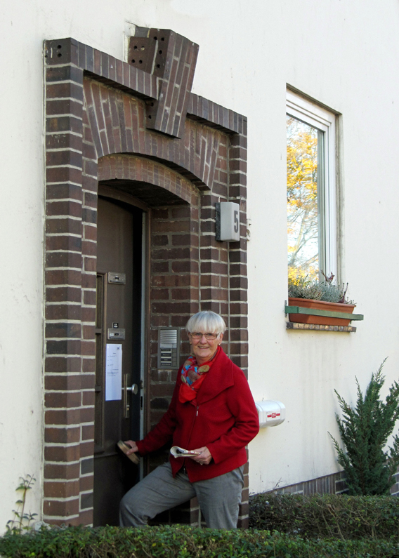 Rosemarie vor ihrer Haustuer mit Zeitung 