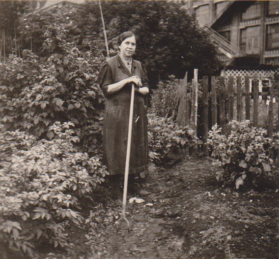 Oma bei der Gartenarbeit. Im Hintergrund die Firma Salzmann. 