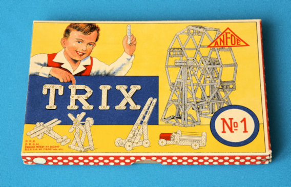 Deckel eines Trix Metallbaukasten aus den 1950er Jahren, strahlender Junge zeigt auf Trix und die Metallobjekte 