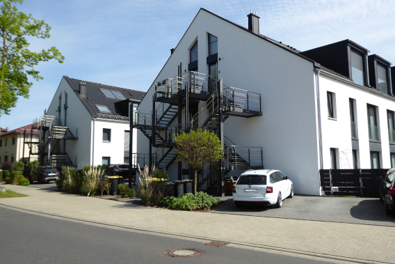 Neue weise moderne Wohnhäuser Kasseler Straße 42a-c, 2025, davor parkt ein PKW