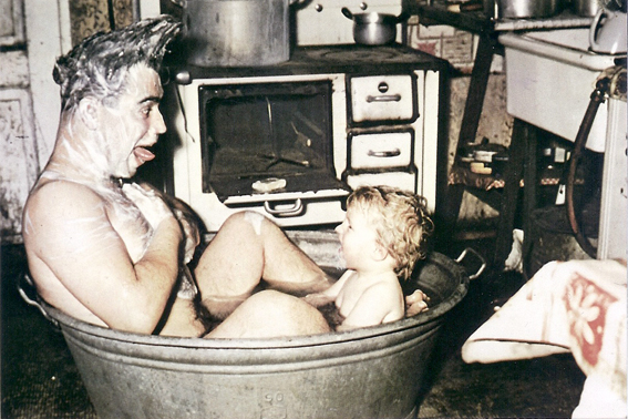 Vater und Sohn sitzen in einer Zinkwanne in der Küche, 1956 