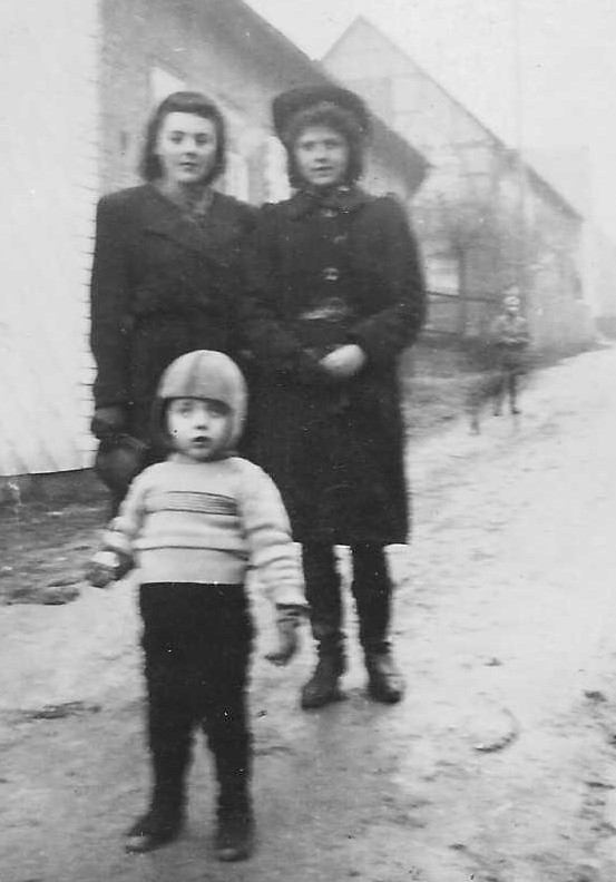 Wilfried Strube mit Fliegermütze steht als Kleinkind vor seiner Mtter und Tante in Kleinalmerode, 1944 
