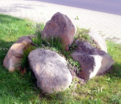 Die Skulptur besteht aus fünf Steinen, die bei Kanalbauarbeiten aus dem Untergrund geholt wurden 